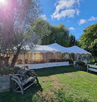 A tiny rustic sail cloth marquee set up for a vintage garden party