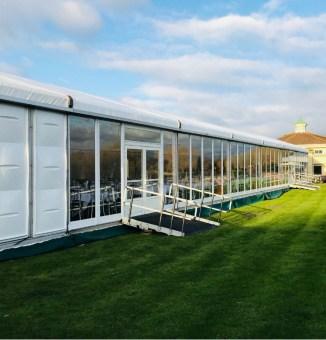 Hard sided corporate marquee built upon a cassette floor on sloping ground