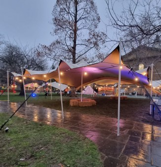 Tan stretch tent being used for a VIP holding area in London before a concert